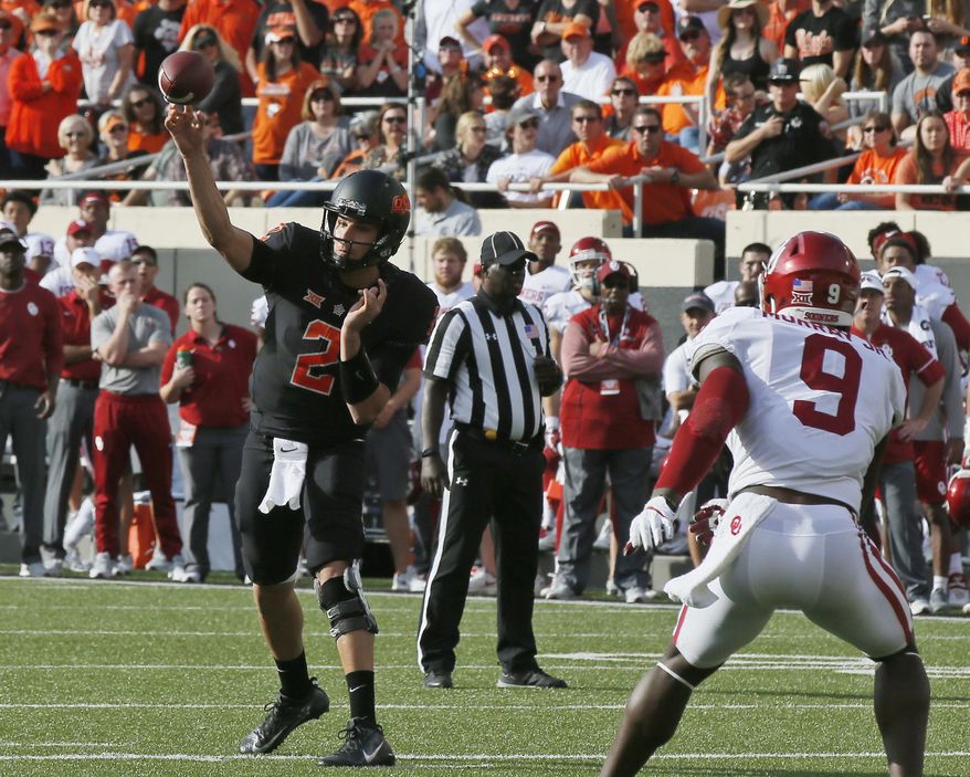 Oklahoma State quarterback Mason Rudolph (2) passes in front of Oklahoma linebacker Kenneth Murray (9) in the first half of an NCAA college football game in Stillwater, Okla., Saturday, Nov. 4, 2017. (AP Photo/Sue Ogrocki)
