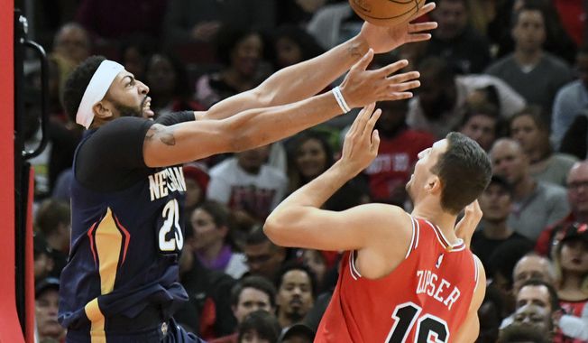 New Orleans Pelicans forward Anthony Davis (23) and Chicago Bulls forward Paul Zipser (16) go for the ball during the first half of an NBA basketball game, Saturday, Nov. 4, 2017, in Chicago. (AP Photo/David Banks)