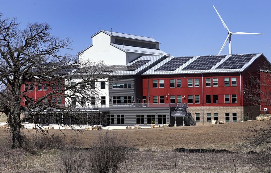 In this April 18, 2016 photo, the new Organic Valley office building in Cashton, Wis., is equipped with solar panels which contribute to the buildings exclusively green power supply. Organic Valley is planning a major investment in solar electricity that could substantially increase Wisconsin's solar capacity and reduce electric bills for rural consumers. (Peter Thomson/La Crosse Tribune via AP)