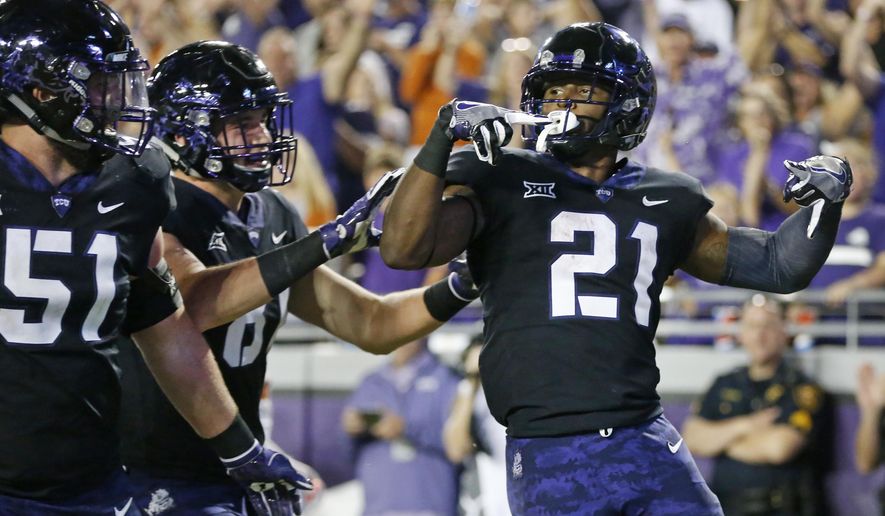 TCU running back Kyle Hicks (21) celebrates with teammates including guard Austin Schlottmann (51) after scoring a touchdown against Texas during the first half of an NCAA college football game Saturday, Nov. 4, 2017, in Fort Worth, Texas. (AP Photo/Ron Jenkins)