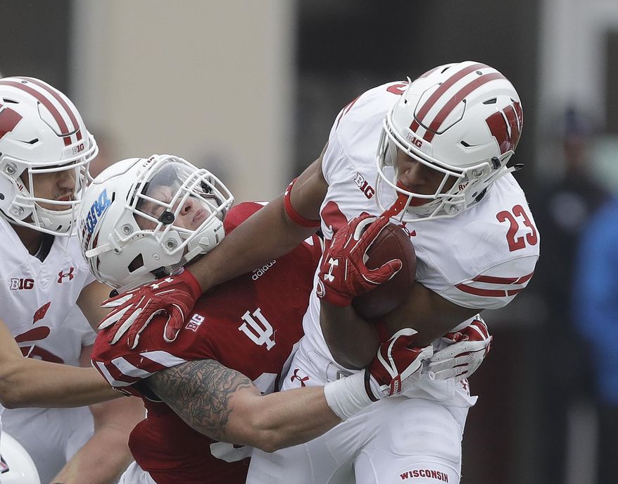 Wisconsin running back Jonathan Taylor (23) runs out of the tackle of Indiana's Chase Dutra (30) during the first half of an NCAA college football game, Nov. 4, 2017, in Bloomington, Ind. (AP Photo/Darron Cummings)