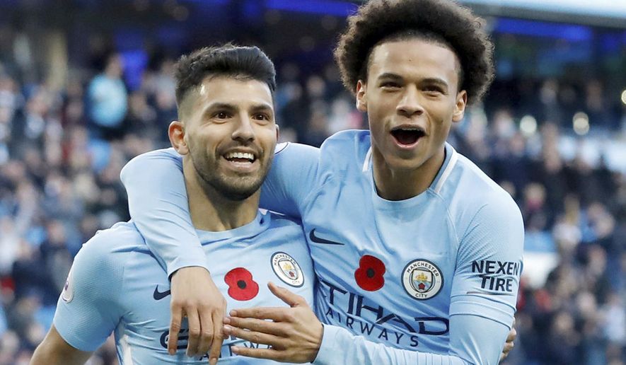 Manchester City's Sergio Aguero, left, celebrates scoring his side's second goal of the game with teammate Leroy Sane, during the English Premier League soccer match between Manchester City and Arsenal, at the Etihad Stadium, in Manchester, Sunday, Nov. 5, 2017. (Martin Rickett/PA via AP)