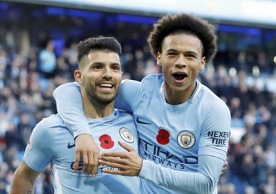 Manchester City's Sergio Aguero, left, celebrates scoring his side's second goal of the game with teammate Leroy Sane, during the English Premier League soccer match between Manchester City and Arsenal, at the Etihad Stadium, in Manchester, Sunday, Nov. 5, 2017. (Martin Rickett/PA via AP)