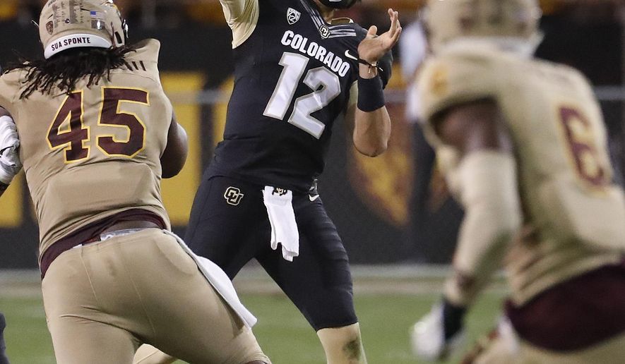 Colorado quarterback Steven Montez (12) throws as Arizona State defensive lineman George Lea (45) pursues during the first half of an NCAA college football game, Saturday, Nov. 4, 2017, in Tempe, Ariz. (AP Photo/Matt York)
