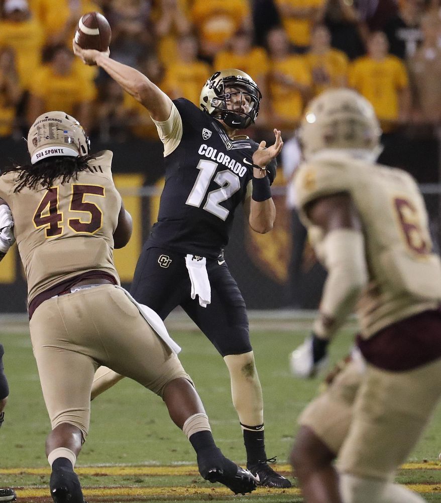 Colorado quarterback Steven Montez (12) throws as Arizona State defensive lineman George Lea (45) pursues during the first half of an NCAA college football game, Saturday, Nov. 4, 2017, in Tempe, Ariz. (AP Photo/Matt York)