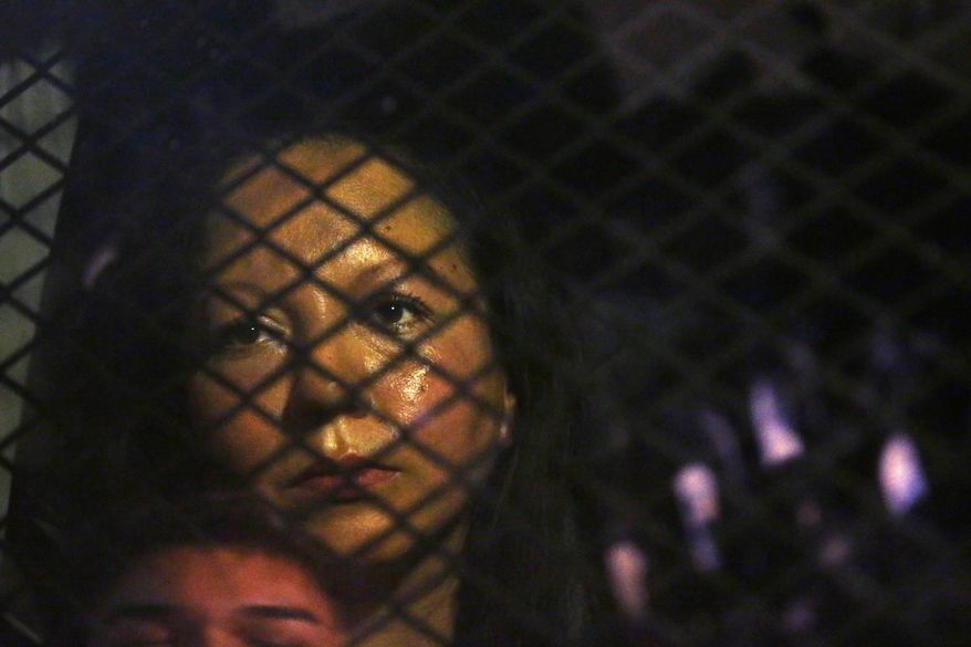 FILE - In this Feb. 8, 2017 file photo, Guadalupe Garcia de Rayos is locked in a van that is stopped in the street by protesters outside the Immigration and Customs Enforcement facility in Phoenix. Advocacy groups said that Immigration and Customs Enforcement officers are rounding up people in large numbers around the country as part of stepped-up enforcement under President Donald Trump, a decade-old deterrence program for prosecuting immigrants in its get-tough approach to immigration. But it's unclear just how effective that program is. (Rob Schumacher/The Arizona Republic via AP, File)
