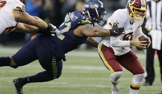 Washington Redskins quarterback Kirk Cousins, right, scrambles away from a tackle attempt by Seattle Seahawks defensive end Michael Bennett, left, in the second half of an NFL football game, Sunday, Nov. 5, 2017, in Seattle. (AP Photo/Stephen Brashear) ** FILE **