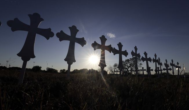 The sun sets behind 26 crosses placed in a field before a vigil for the victims of the First Baptist Church shooting Monday, Nov. 6, 2017, in Sutherland Springs, Texas. Texas officials confirmed Devin Patrick Kelley as the shooter who killed at least 26 people and wounded about 20 others at the church. (AP Photo/David J. Phillip) ** FILE **