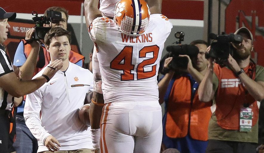 Clemson's Christian Wilkins (42) lifts quarterback Kelly Bryant (2) following Bryant's touchdown against North Carolina State during the second half of an NCAA college football game in Raleigh, N.C., Saturday, Nov. 4, 2017. Clemson won 38-31. (AP Photo/Gerry Broome)