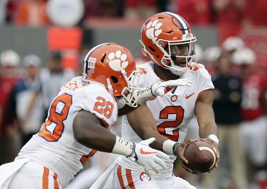 Clemson quarterback Kelly Bryant (2) hands off to Tavien Feaster (28) during the first half of an NCAA college football game against North Carolina State in Raleigh, N.C., Saturday, Nov. 4, 2017. (AP Photo/Gerry Broome)