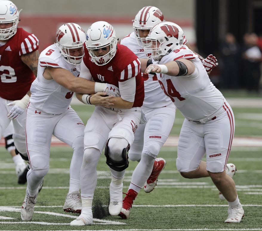 Indiana quarterback Richard Lagow (21) is tackled by Wisconsin's Garret Dooley (5) and Conor Sheehy (94) during the second half of an NCAA college football game, Nov. 4, 2017, in Bloomington, Ind. Wisconsin won 45-17. (AP Photo/Darron Cummings)