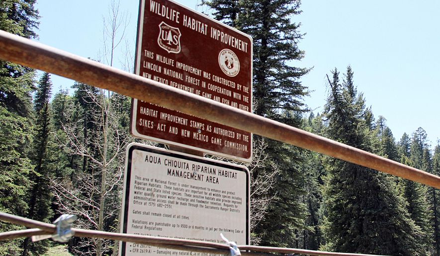 FILE - This May 15, 2014, file photo shows a newly posted warning sign barring cattlemen from using a watering hole they previously had access to in Lincoln National Forest near Weed, N.M. A U.S. court has sided with a New Mexico ranching family in a decades-long battle over access to water on national forest land, providing more certainty that state law allows for the protection of water rights dating back more than a century. The case of the Goss family has been closely watched by thousands of ranchers who hold grazing permits across the West. (AP Photo/Juan Carlos Llorca, File)