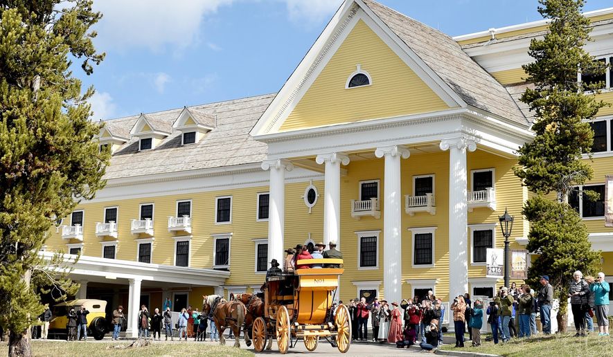 FILE - In this May 13, 2016 file photo, the historic yellow stagecoach arrives at the Lake Yellowstone Hotel as the crowd takes photos during the 125th anniversary celebration of the hotel. A legislative panel is considering a new tax to help fund Wyoming's tourism promotion efforts. The Legislature's Joint Revenue Committee on Tuesday, Nov. 7, 2017 is drafting a bill that would impose a 1 percent tax at hotels, restaurants, bars and other leisure and hospitality establishments around the state. (Hannah Potes/The Billings Gazette via AP, File)