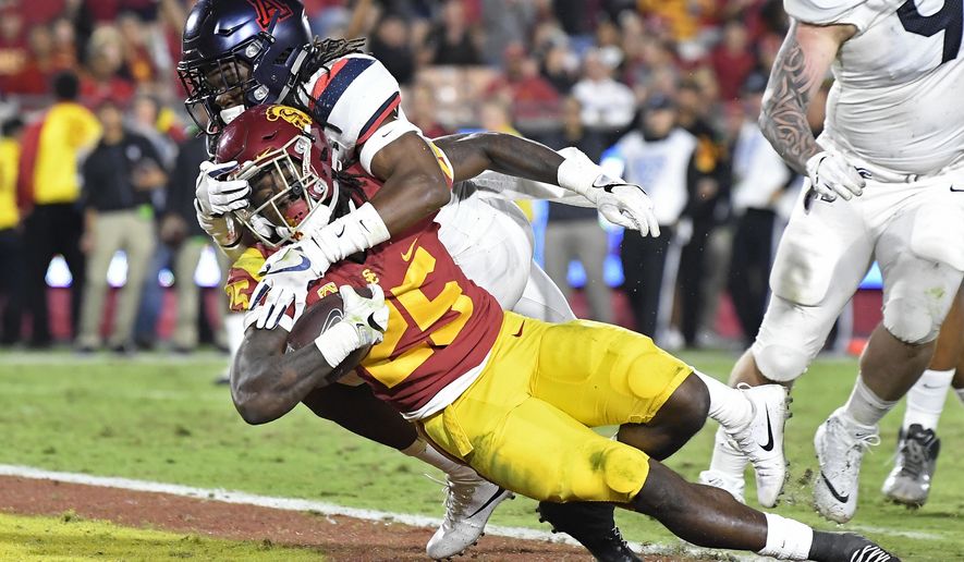 Southern California running back Ronald Jones II, below, dives in for a touchdown while being tackled by Arizona safety Jarrius Wallace during the second half of an NCAA college football game, Saturday, Nov. 4, 2017, in Los Angeles. USC won 49-35. (AP Photo/Mark J. Terrill)