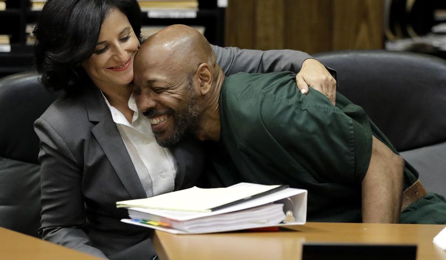 FILE-This Sept. 15, 2017, file photo shows Eric Kelley, right, being hugged by his lawyer Vanessa Potkin moments after Passaic County Superior Court Judge Joseph Portelli granted Kelley a retrial in the case in which he was found guilty of the killing of a video store employee during a robbery in 1993, during a hearing, in Paterson, N.J. Kelly and Ralph Lee, imprisoned for nearly a quarter-century in the killing of a New Jersey video store clerk, have been released on bail to await new trials. Kelley and Lee left the Passaic County Jail on Wednesday, Nov. 8, 2017. Their convictions were overturned after new tests found someone else's DNA on a key piece of evidence. (AP Photo/Julio Cortez, File)