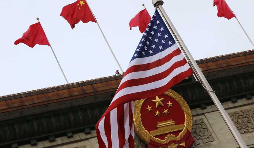 An American flag is flown next to the Chinese national emblem and flags during a welcome ceremony for visiting U.S. President Donald Trump outside the Great Hall of the People in Beijing, Thursday, Nov. 9, 2017. President Donald Trump sought to present a united front with Chinese President Xi Jinping following two days of meetings Thursday, despite lingering differences over trade and North Korea. (AP Photo/Andy Wong)