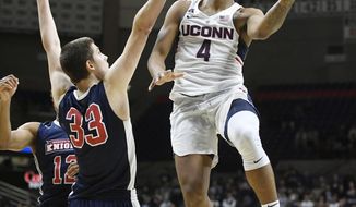 Connecticut&#39;s Jalen Adams goes up for a basket as Queens College&#39;s Kevin Buron defends in the second half of an NCAA college exhibition basketball game Sunday, Nov. 5, 2017, in Storrs, Conn. (AP Photo/Jessica Hill)