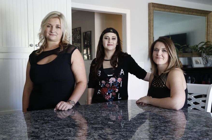 In this Tuesday, Oct. 31, 2017, photo, from left, Hillary Kane, Samantha Carranza and Lacey Tucker pose for a portrait in Las Vegas. The three are trying a track down a man and woman who helped them during the shooting at the Route 91 Harvest festival in Las Vegas. (AP Photo/John Locher)