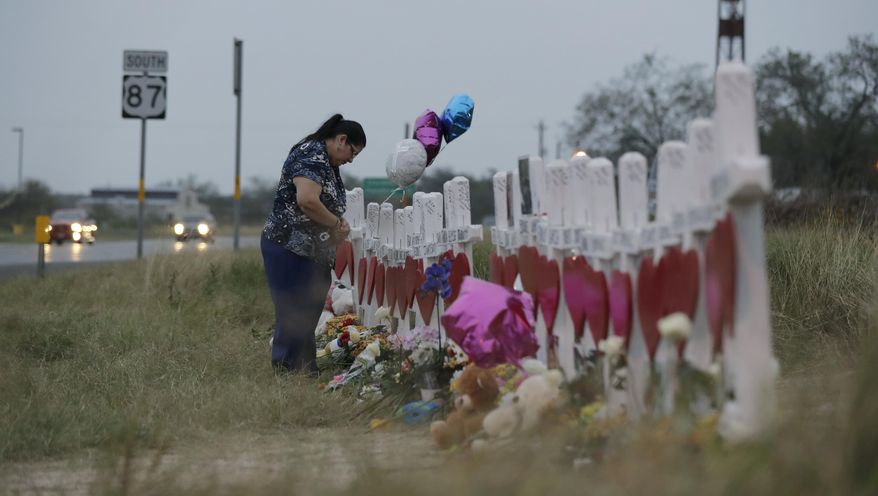 A woman visits a makeshift memorial along the highway for the victims of the church shooting at Sutherland Springs Baptist Church, Friday, Nov. 10, 2017, in Sutherland Springs, Texas. A man opened fire inside the church in the small South Texas community on Sunday, killing more than two dozen. (AP Photo/Eric Gay)