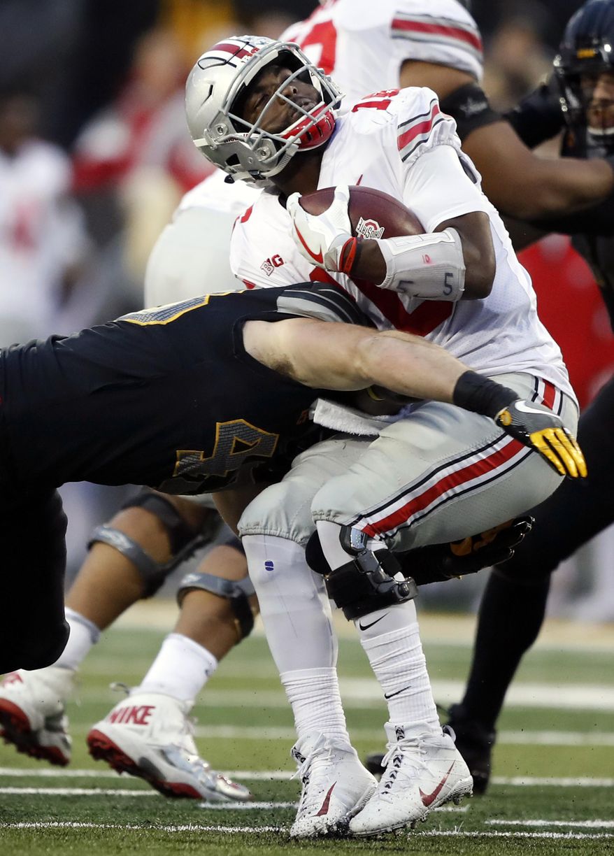 Ohio State quarterback J.T. Barrett is tackled by Iowa linebacker Josey Jewell, left, during the second half of an NCAA college football game, Saturday, Nov. 4, 2017, in Iowa City, Iowa. (AP Photo/Charlie Neibergall)
