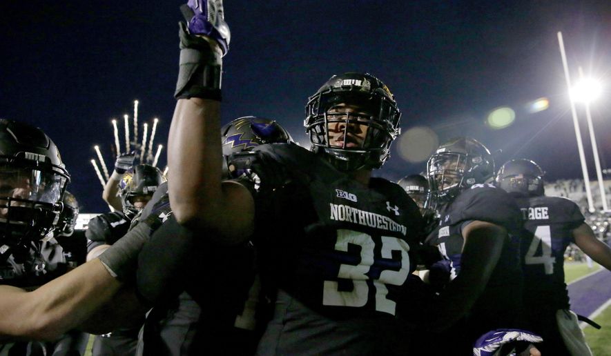 FILE - In this Oct. 28, 2017, file photo, Northwestern linebacker Nate Hall (32) celebrates with teammates after intercepting a pass from Michigan State quarterback Brian Lewerke during the third overtime of an NCAA college football game in Evanston, Ill. Northwestern, which has won three consecutive overtime games, plays Purdue this week. (AP Photo/Nam Y. Huh, File)