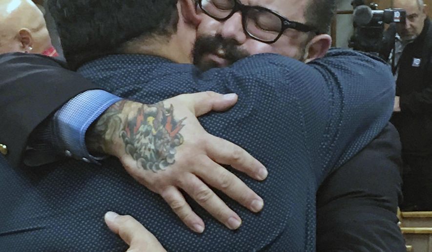 Christopher "Jake" Carrizal, right, gets a hug following a mistrial, Friday, Nov. 10, 2017, in Waco, Texas. The Dallas chapter president of the Bandidos motorcycle club is the first to stand trial involving the 2015 shootout where nine people were fatally shot and 18 people were injured outside of Twin Peaks restaurant. (Tommy Witherspoon/Waco Tribune-Herald via AP)
