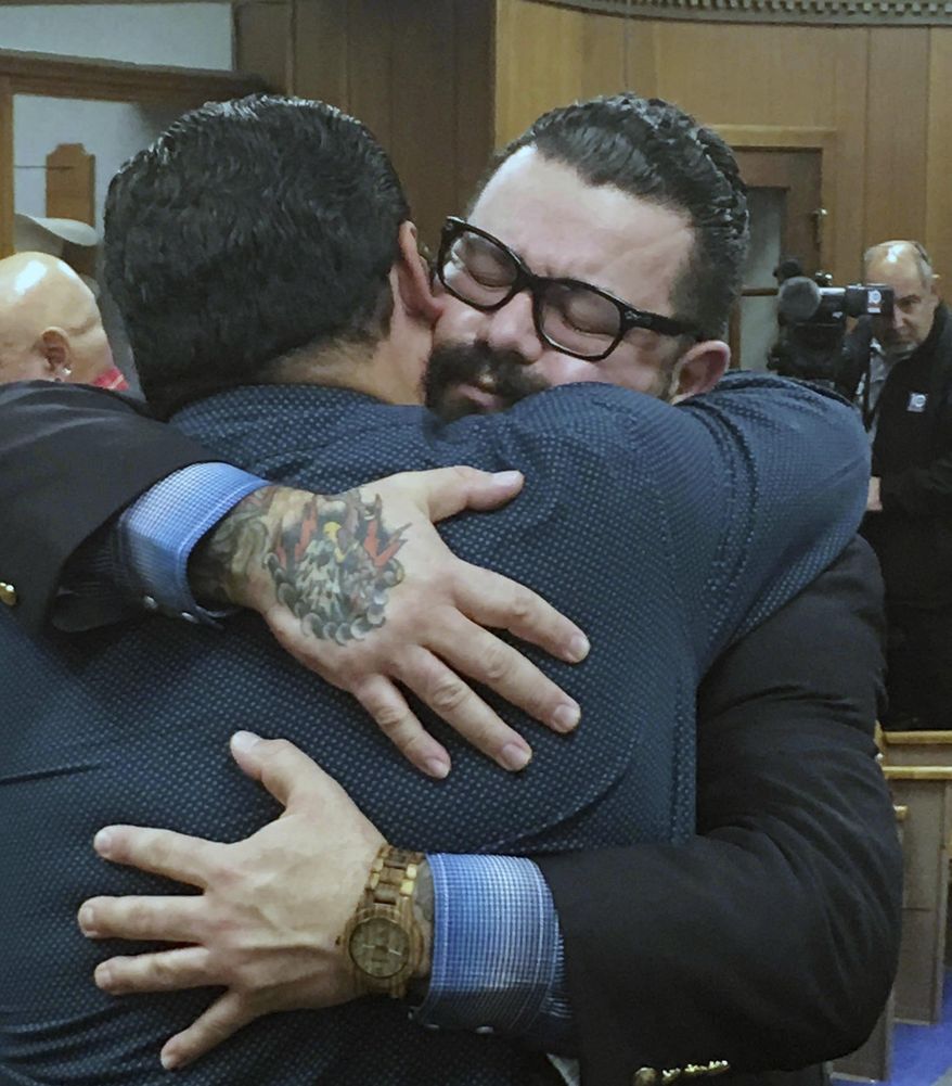 Christopher "Jake" Carrizal, right, gets a hug following a mistrial, Friday, Nov. 10, 2017, in Waco, Texas. The Dallas chapter president of the Bandidos motorcycle club is the first to stand trial involving the 2015 shootout where nine people were fatally shot and 18 people were injured outside of Twin Peaks restaurant. (Tommy Witherspoon/Waco Tribune-Herald via AP)