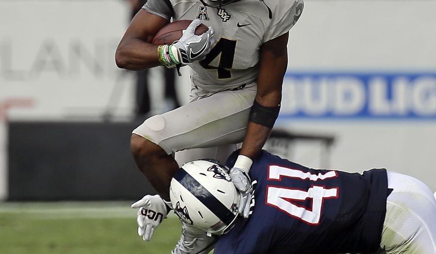 Central Florida wide receiver Tre'Quan Smith (4) tries to gain yardage after a reception past Connecticut defensive back Marshe Terry (41) during the first half of an NCAA college football game, Saturday, Nov. 11, 2017, in Orlando, Fla. (AP Photo/John Raoux)