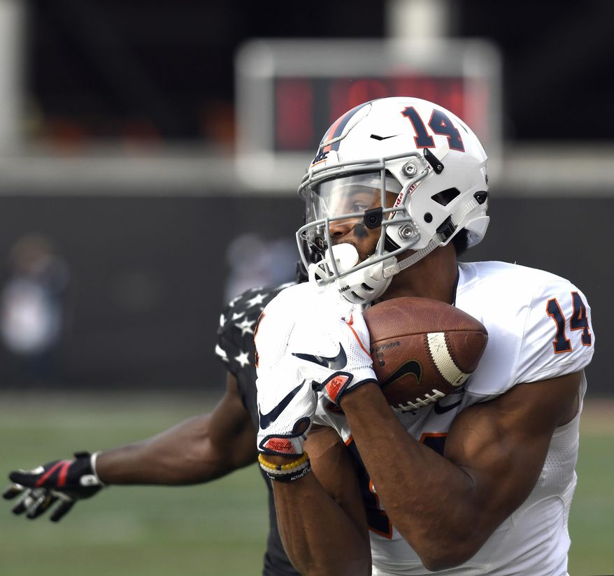 Virginia wide receiver Andre Levrone (14) pulls in a pass ahead of the defense of Louisville cornerback Trumaine Washington (15) during the first half of an NCAA college football game, Saturday, Nov. 11, 2017, in Louisville, Ky. (AP Photo/Timothy D. Easley)