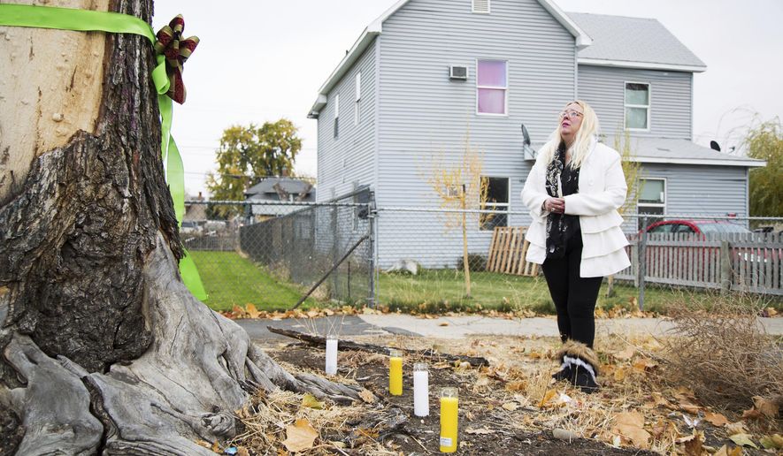 Elizabeth Ramos is emotional after setting up a memorial of ribbons, candles and flowers for her stepsister Theresa Lumley near the intersection of East Spruce and South Sixth Streets in Yakima, Wash., Saturday, Nov. 4, 2017. Lumely was killed in a hit-and-run near the site on Oct. 28. Police don't yet have any suspects in the investigation. (Shawn Gust/Yakima Herald-Republic via AP)