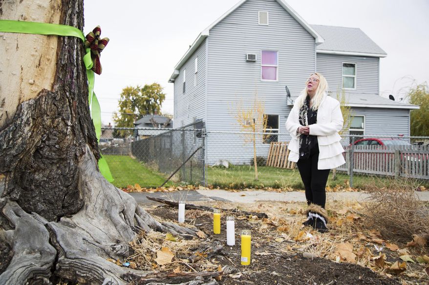 Elizabeth Ramos is emotional after setting up a memorial of ribbons, candles and flowers for her stepsister Theresa Lumley near the intersection of East Spruce and South Sixth Streets in Yakima, Wash., Saturday, Nov. 4, 2017. Lumely was killed in a hit-and-run near the site on Oct. 28. Police don't yet have any suspects in the investigation. (Shawn Gust/Yakima Herald-Republic via AP)