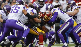 Washington Redskins running back Rob Kelley (20) is swarmed by the Minnesota Vikings defense during the first half of an NFL football game in Landover, Md., Sunday, Nov. 12, 2017. (AP Photo/Patrick Semansky)