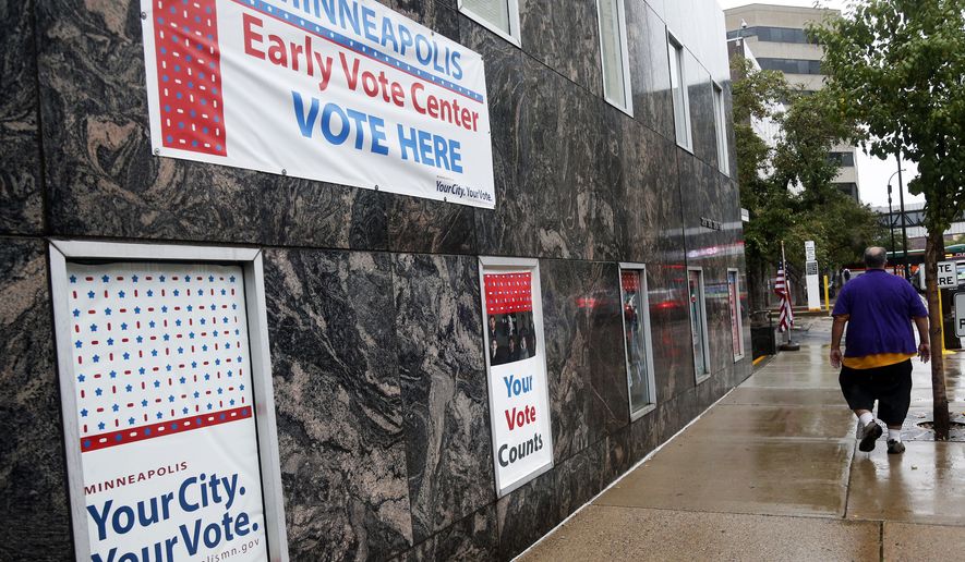 Signs on a building advertise early voting Friday, Sept. 23, 2016, in Minneapolis. Election Day is more than a month away but the voting was already underway Friday, as Minnesota kicked off its first presidential cycle where all voters across the state can cast their ballots early. (AP Photo/Jim Mone)