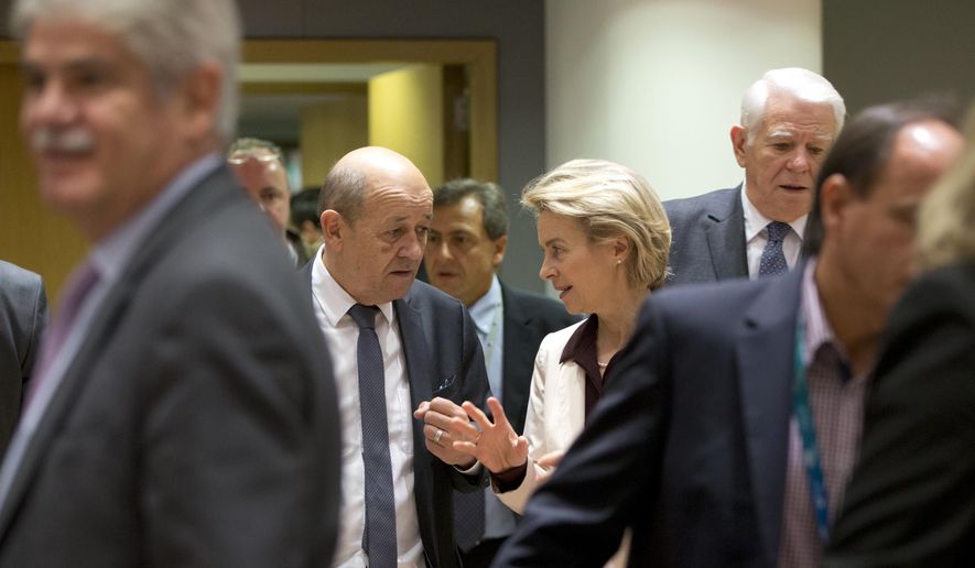 French Foreign Minister Jean-Yves Le Drian, center left, speaks with German Defense Minister Ursula von der Leyen, center right, during a meeting of EU foreign and defense ministers at the Europa building in Brussels, Monday, Nov. 13, 2017. The European Union is banning arms sales to Venezuela and setting up a system for asset freezes and travel restrictions on some Venezuelan officials to ramp up pressure on President Nicolas Maduro. (AP Photo/Virginia Mayo)