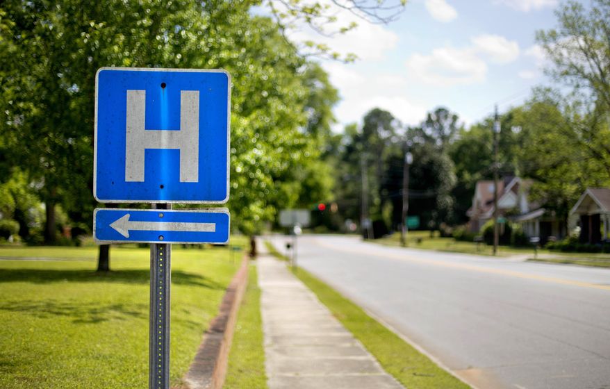 FILE - In this April 25, 2014, file photo, a sign points the way to a hospital in Georgia. A study shows that Medicare patients with common illnesses who were treated by their own familiar primary care doctors were slightly more likely to survive after being sent home than those treated by hospitalists, internists who don't provide care outside of hospitals. (AP Photo/David Goldman, File)