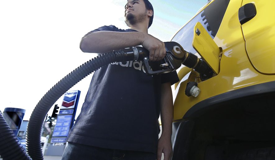 FILE - In this Monday, Oct. 30, 2017, file photo, Cristian Rodriguez fuels his vehicle in Sacramento, Calif. The price of oil has risen by about one-third since the summer, but many experts think the surge won’t last. They point to growing U.S. production. Still, higher prices for energy could translate into higher prices for airline tickets and consumer goods. (AP Photo/Rich Pedroncelli, File)