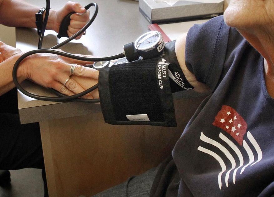 In this June 6, 2013, file photo, a patient has her blood pressure checked by a registered nurse in Plainfield, Vt. New medical guidelines announced Monday, Nov. 13, 2017, lower the threshold for high blood pressure. (AP Photo/Toby Talbot, File)