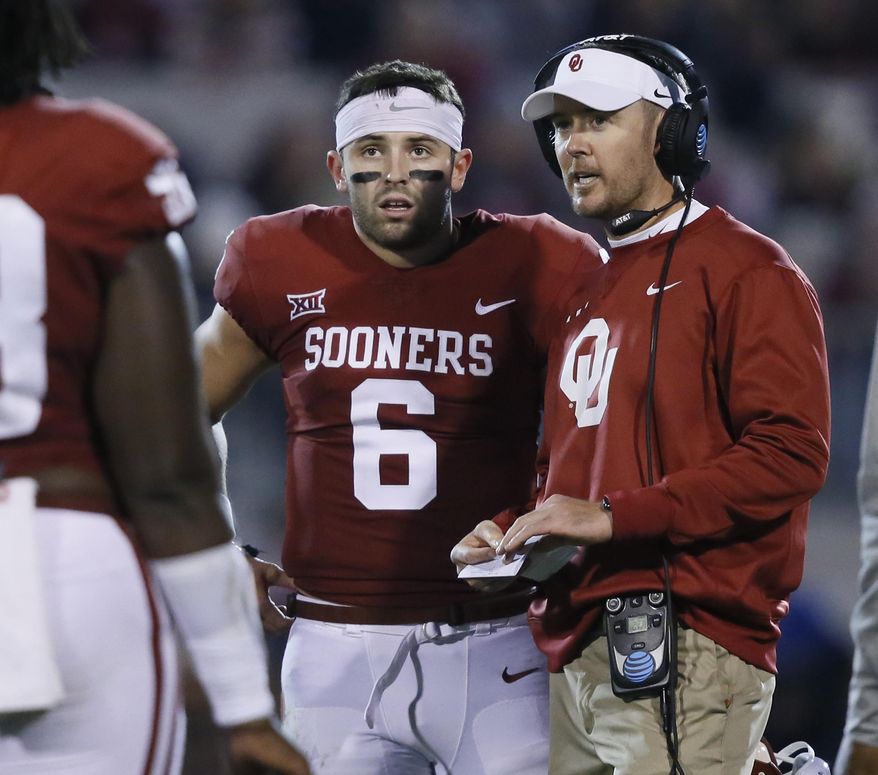 Oklahoma head coach Lincoln Riley, right, talks with quarterback Baker Mayfield (6) in the first quarter of an NCAA college football game against TCU in Norman, Okla., Saturday, Nov. 11, 2017. Oklahoma won 38-20. (AP Photo/Sue Ogrocki)