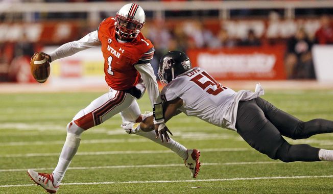 Utah quarterback Tyler Huntley (1) eludes the tackle from Washington State linebacker Frankie Luvu (51) in the second half of an NCAA college football game Saturday, Nov. 11, 2017, in Salt Lake City. (AP Photo/Rick Bowmer)