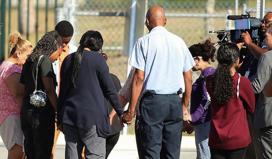 Parents prayed in front of Lake Minneola High School in Florida on Tuesday after a student shot and killed himself there. Researchers have found a disturbingly strong correlation between heavy social media use and teenage suicide, along with other mental health issues. (Associated Press)