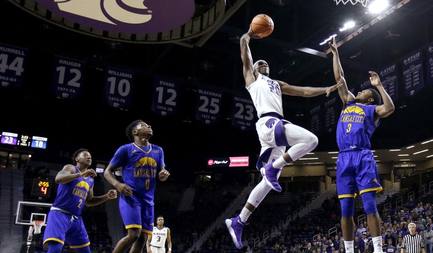 Kansas State's Xavier Sneed (20) gets past UKMC's Brandon McKissic (3) for a dunk during the first half of an NCAA college basketball game, Tuesday, Nov. 14, 2017, in Manhattan, Kan. (AP Photo/Charlie Riedel)