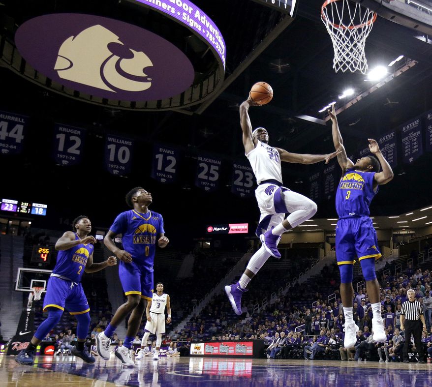 Kansas State's Xavier Sneed (20) gets past UKMC's Brandon McKissic (3) for a dunk during the first half of an NCAA college basketball game, Tuesday, Nov. 14, 2017, in Manhattan, Kan. (AP Photo/Charlie Riedel)
