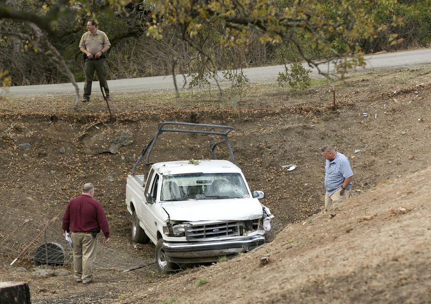 Investigators view a pickup truck involved in a deadly shooting rampage at the Rancho Tehama Reserve, near Corning, Calif., Tuesday, Nov. 14, 2017. A gunman driving stolen vehicles and choosing his targets at random opened fire "without provocation" in the tiny, rural Northern California town Tuesday, killing several people, including a student at an elementary school, before police shot him dead, authorities said. (AP Photo/Rich Pedroncelli)