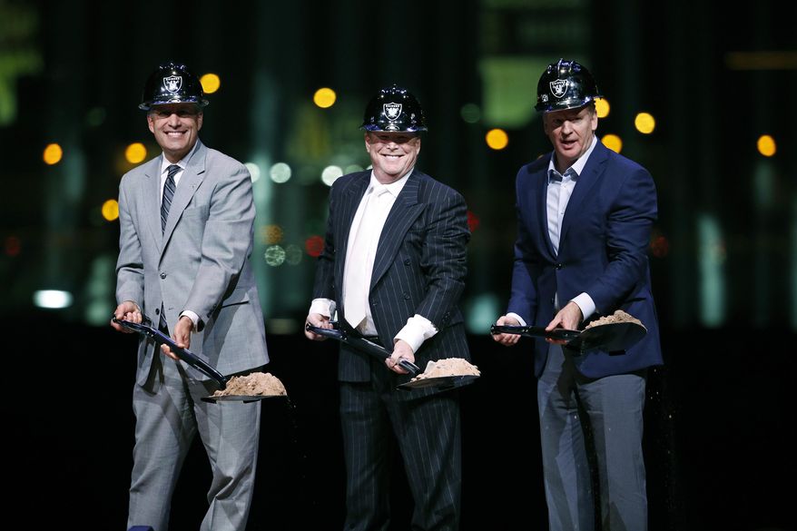Oakland Raiders owner Mark Davis, center, poses for photographs beside Nevada Gov. Brian Sandoval, left, and NFL Commissioner Roger Godell during a ceremonial groundbreaking for the Raiders' stadium Monday, Nov. 13, 2017, in Las Vegas. After years of planning, dealing and getting millions in public financing approved, the team broke ground on a 65,000-seat domed stadium in Las Vegas, across the freeway from the city's world-famous casinos. (AP Photo/John Locher)