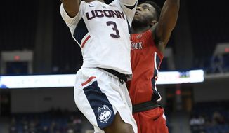 Connecticut&#39;s Alterique Gilbert shoots as Stony Brook&#39;s Elijah Olaniyi, right, defends, during the first half of an NCAA college basketball game, Tuesday, Nov. 14, 2017, in Hartford, Conn. (AP Photo/Jessica Hill)