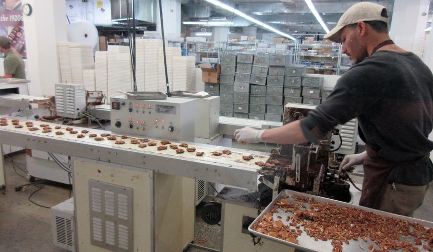 FILE - This April 28, 2017, file photo shows a worker at Li-Lac Chocolates' factory in Industry City in the Brooklyn borough of New York. On Wednesday, Nov. 15, 2017, the Federal Reserve of New York releases its November survey of manufacturers in the state. (AP Photo/Beth J. Harpaz, File)