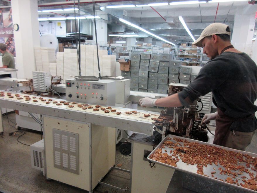 FILE - This April 28, 2017, file photo shows a worker at Li-Lac Chocolates' factory in Industry City in the Brooklyn borough of New York. On Wednesday, Nov. 15, 2017, the Federal Reserve of New York releases its November survey of manufacturers in the state. (AP Photo/Beth J. Harpaz, File)