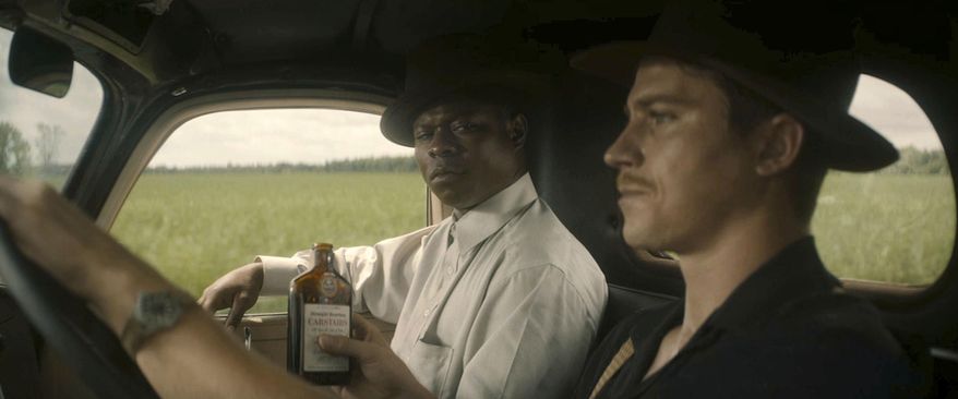 This image released by Netflix shows Jason Mitchell, left, and Garrett Hedlund in a scene from "Mudbound." (Netflix via AP)