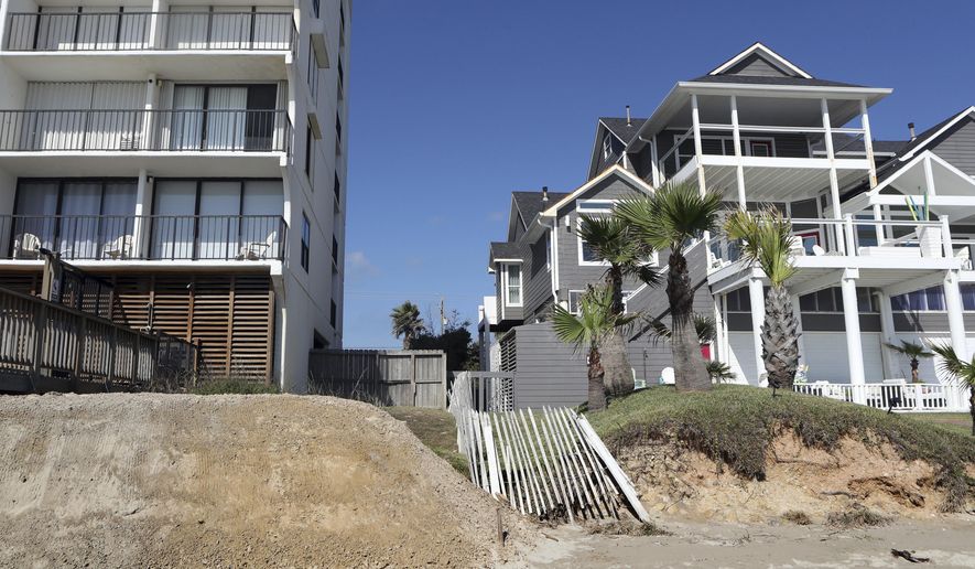 In this Tuesday, Nov. 14, 2017 photo, a new dune is piled behind the West Beach Grand Condos next to a house without a dune in the Sands of Kahala neighborhood in Galveston, Texas. The relaxation of state regulations after Hurricane Harvey has allowed Texas coastal communities to undertake nearly a dozen dune reconstruction projects. (Kelsey Walling /The Galveston County Daily News via AP)