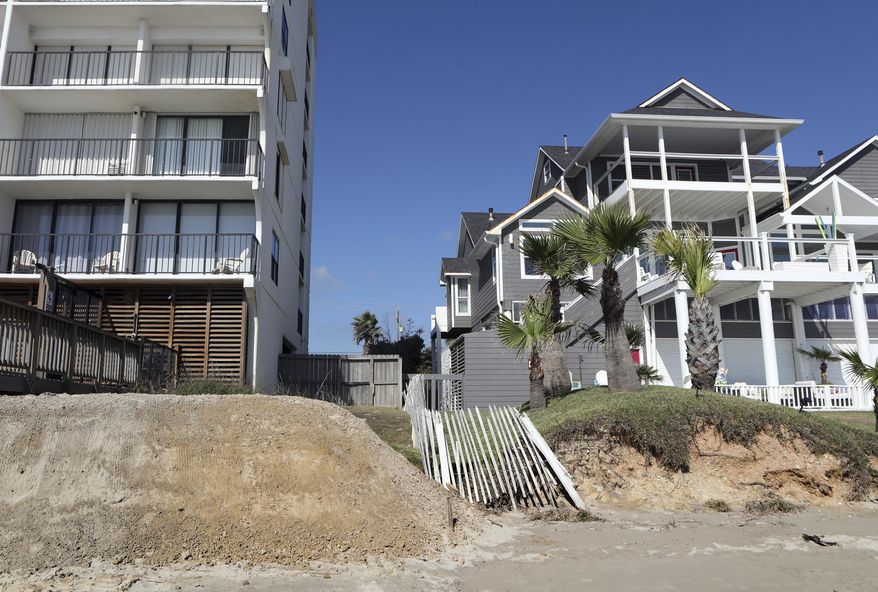 In this Tuesday, Nov. 14, 2017 photo, a new dune is piled behind the West Beach Grand Condos next to a house without a dune in the Sands of Kahala neighborhood in Galveston, Texas. The relaxation of state regulations after Hurricane Harvey has allowed Texas coastal communities to undertake nearly a dozen dune reconstruction projects. (Kelsey Walling /The Galveston County Daily News via AP)